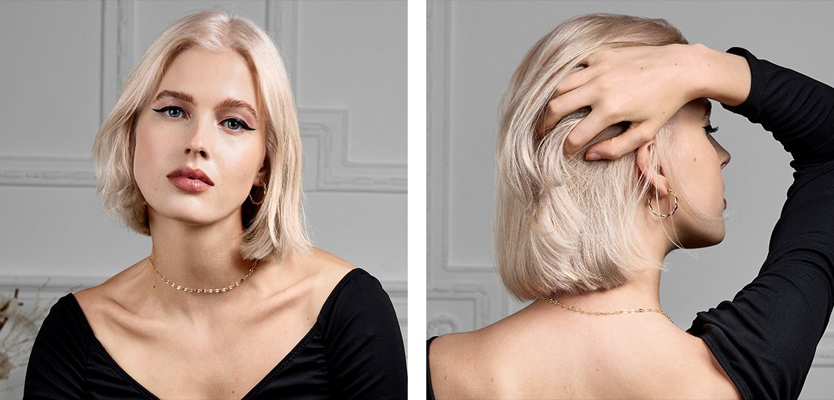 Eine Frau mit mittellangen blonden Haaren in der Mitte gescheitelt.